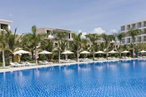 una grande piscina con sedie e ombrelloni di CostaBella Resort Nha Trang a Nha Trang