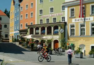 a group of people riding bikes on a city street at Hotel Stiegenwirt in Schärding