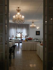 una sala da pranzo con tavoli e lampadario pendente di Park Hotel ad Albisola Superiore