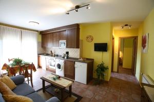 cocina y sala de estar con sofá y mesa en Apartamentos Rurales La Viña, en Cangas de Onís