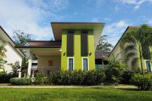 een geel en wit huis met een tuin bij Bai Bai Home in Khao Lak