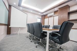 uma sala de conferências com uma mesa e cadeiras e um quadro branco em Bed and Bath Serviced Suites em Iloilo