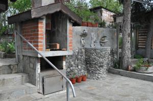 un horno de ladrillo al aire libre en un jardín con macetas en Holiday Home Vilata, en Kardzhali