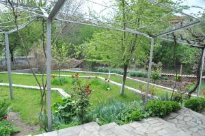 a garden with flowers and a pergola at Holiday Home Vilata in Kŭrdzhali