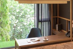 an office with a desk and a chair and a window at Volve Hotel Bangkok in Bangkok