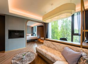 a living room with a couch and a large window at Volve Hotel Bangkok in Bangkok