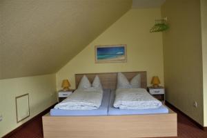 sypialnia z 2 łóżkami i białymi poduszkami w obiekcie Fewo's Kiekut w mieście Lohme
