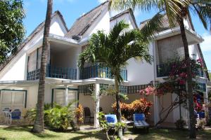 uma casa com palmeiras em frente em Blue Bird em Pereybere