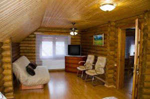 a living room with a tv and two chairs at Liubava in Polyana