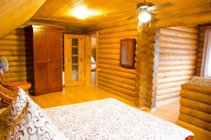 ein Schlafzimmer mit einem Bett in einer Blockhütte in der Unterkunft Liubava in Poljana