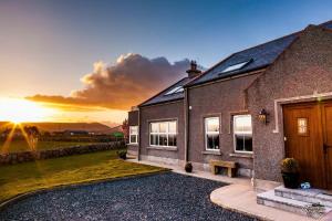 a house with a sunset in the background at Samona in Kilkeel