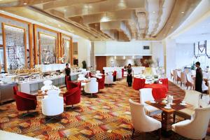 a restaurant with red and white tables and chairs at Glarun Jinling Hotel in Nanjing