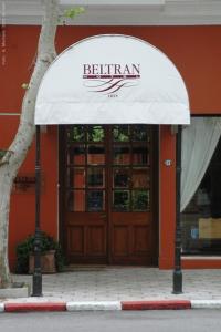 ein Gebäude mit einer weißen Markise vor einer Tür in der Unterkunft Hotel Beltran in Colonia del Sacramento