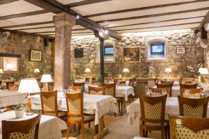 a restaurant with tables and chairs and a stone wall at Hostellerie Schwendi in Kientzheim