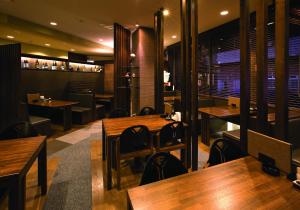 a restaurant with wooden tables and chairs at Kiryu Ace Hotel in Kiryu