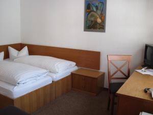 a hotel room with a bed and a desk and a television at Dresdner Höhe in Dresden