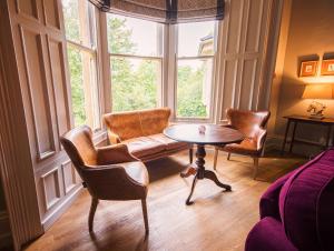 uma sala de estar com um sofá e uma mesa em frente a uma janela em Eslington Villa em Gateshead