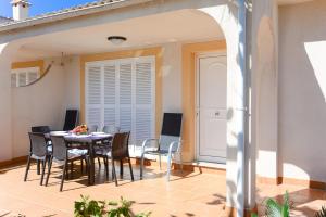 een patio met een tafel en stoelen op een balkon bij Pinya in Port d'Alcudia