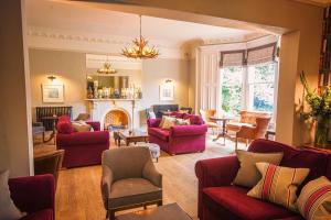 een woonkamer met rode meubels en een open haard bij Eslington Villa in Gateshead