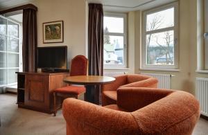 什平德萊魯夫姆林的住宿－Pension Villa Miluška，客厅配有椅子、桌子和电视