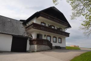 ein großes weißes Haus mit schwarzem Dach in der Unterkunft Gasthof-Pension Urzn in Altmünster