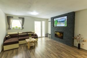 a living room with a couch and a fireplace at Lesní Penzion Vranov in Vranov nad Dyjí