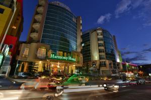 a city street with cars driving past a hotel at Harmony Hotel in Addis Ababa