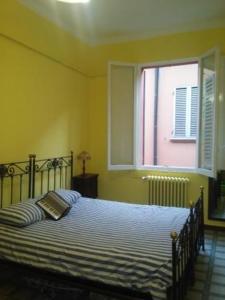 ボローニャにあるa quattro passiのベッドルーム1室(大型ベッド1台、窓付)