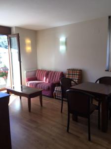 sala de estar con sofá y mesa en Apartaments Alt Aneu Baqueira, en Isavarre