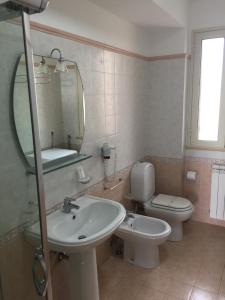 a bathroom with a sink and a toilet and a mirror at Casa Vacanze Samira in Fondachello