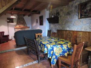 a dining room with a table and chairs and a stone wall at Ablanera 2 in Cangas de Onís