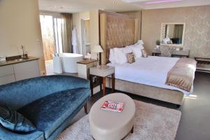 a bedroom with a large bed and a couch at Wild Mushroom Country House in Stellenbosch