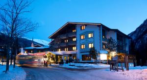 a building with a bus in front of it in the snow at Sporthotel Heiligenblut in Heiligenblut