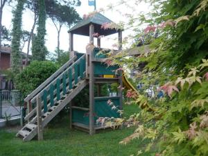 a tree house with a staircase in the grass at Hotel Lily in Bibione