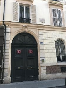 un edificio con una porta nera con due finestre di 1er Etage SoPi-Montmartre a Parigi