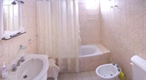 a bathroom with a tub and a toilet and a sink at Edymar in Puerto Madryn +8 photos