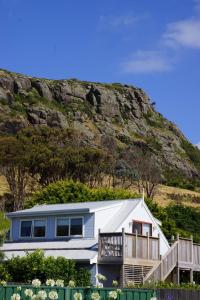a house with a mountain in the background at @ the beach & not quite @ the beach Holiday Cottages - Stanley in Stanley
