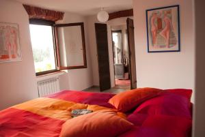 Schlafzimmer mit einem Bett mit bunter Bettwäsche und Kissen in der Unterkunft Otium B&B in Cavallirio