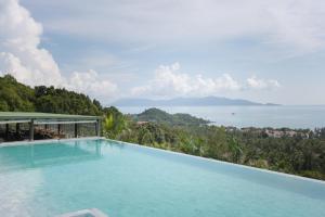 a swimming pool with a view of the ocean at Mantra Samui Resort - Adults Only in Mae Nam