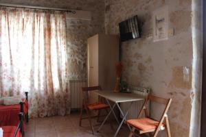 a room with a table and chairs and a window at Artemisia Traditional Home in Choudetsi