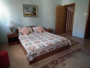 sypialnia z łóżkiem, 2 stołami i lampką w obiekcie Naša Tvrđava Guest Accommodation w Nowym Sadzie