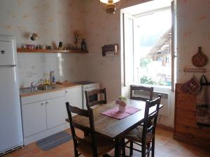a kitchen with a wooden table with chairs and a window at La Tour de Seythenex in Seythenex +24 photos