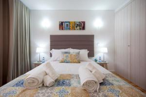 um quarto com uma cama grande e toalhas em FishermenApartments - Santos 4D em Lisboa