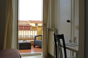 una porta aperta su un balcone con tavolo e sedie di Hotel Indipendenza a Roma