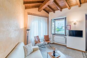 a living room with a couch and a tv at Villa Edy Apartments in Tremezzo
