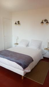 カルカソンヌにあるAppartement au coeur de Carcassonneのベッドルーム(白い大型ベッド、ランプ2つ付)