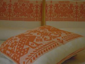 a bed with an orange and white blanket on it at Al mare in Sardegna in Porto San Paolo