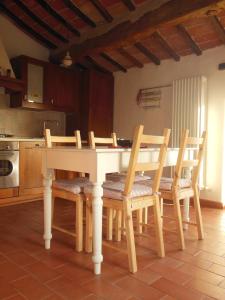 パッシニャーノ・スル・トラジメーノにあるTra lago e collinaのキッチン(白いテーブル、木製椅子付)