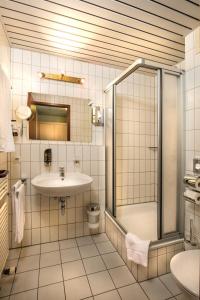 La salle de bains est pourvue d'un lavabo et d'une douche. dans l'établissement DOBLERGREEN Hotel Stuttgart-Gerlingen, à Gerlingen