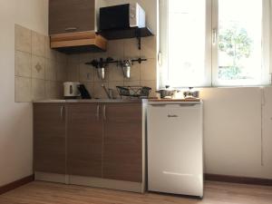 a small kitchen with a refrigerator and a window at Guest House Adriatica by Pinch in Pakoštane